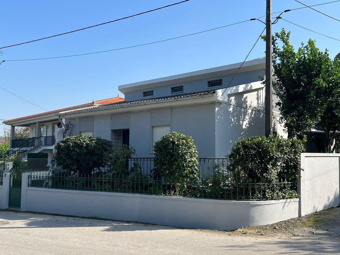 Moradia pintada de cinzento com muro branco