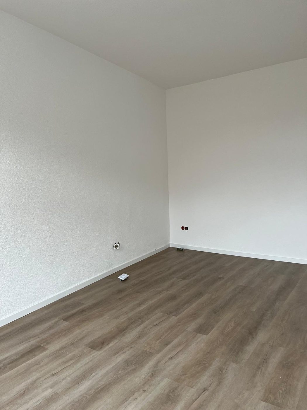 Quarto acabado com paredes brancas e rodapé